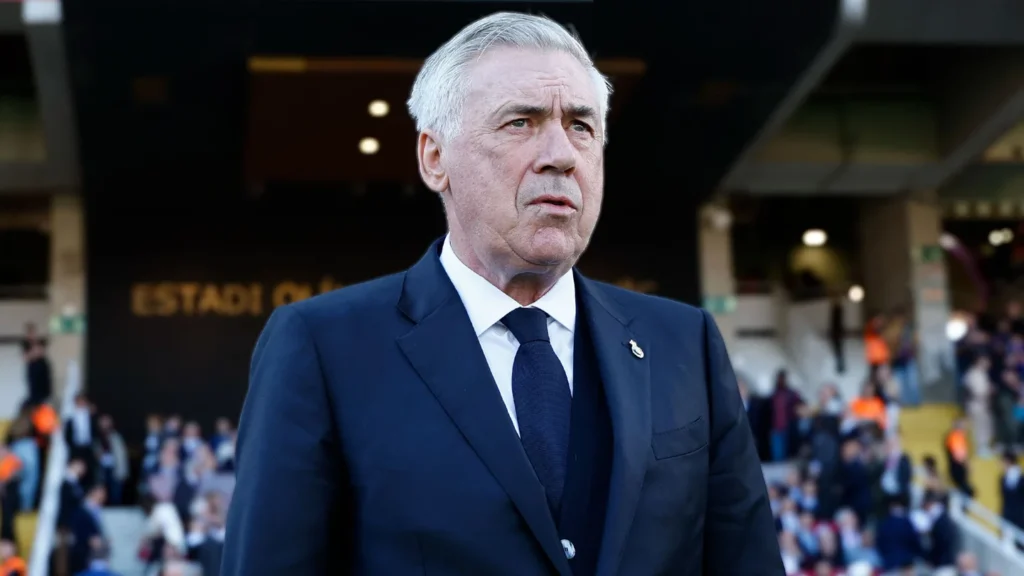 Novo treinador da Seleção Brasileira, Carlo Ancelotti veste terno azul escuro com um broche com um escudo do Real Madrid no peito